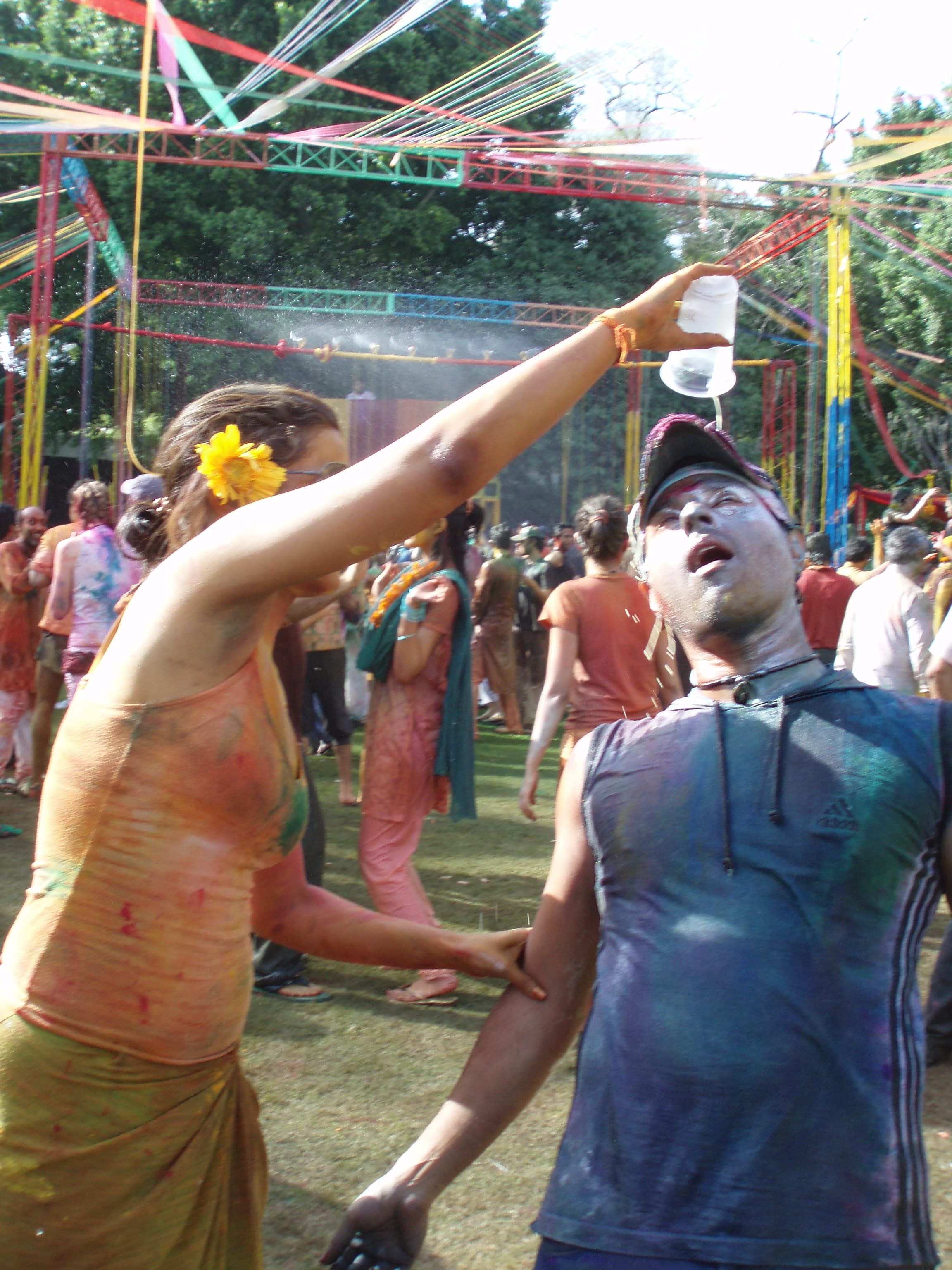 A woman pouring bhang for a man during a Holi celebration in India
